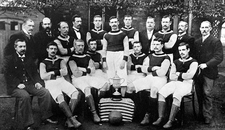 Football team in old-fashioned kit, all seated