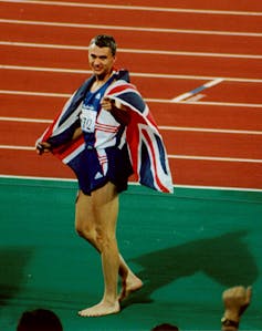 Athlete walking barefoot in stadium with union flag