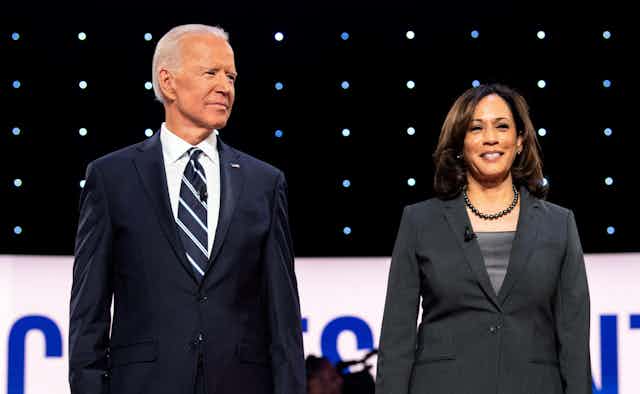 A man in a striped tie next to a woman in a grey jacket.