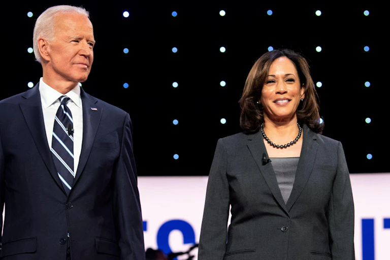 A man in a striped tie next to a woman in a grey jacket.