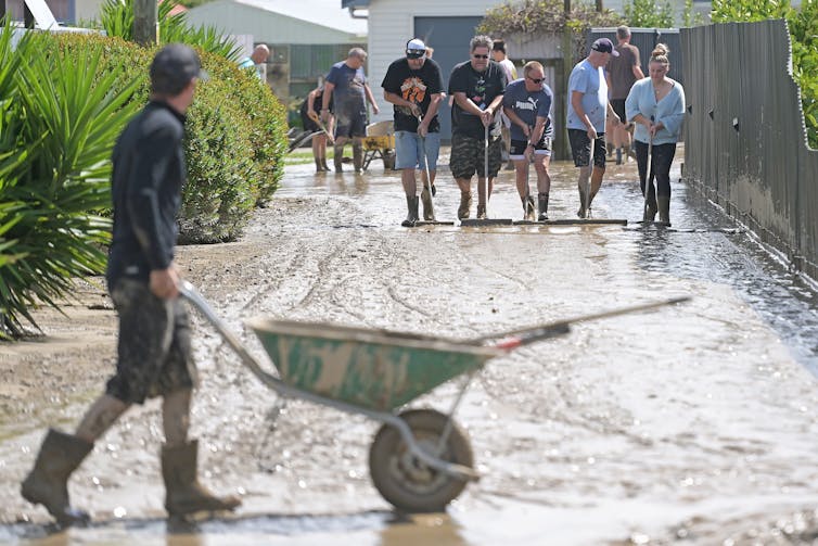 People clearing silt from a farm driveway