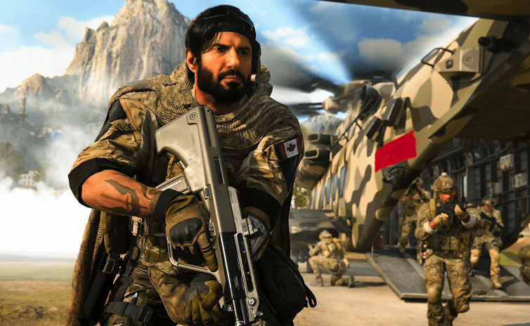 شخصية في لعبة COD ذات لحية داكنة بملابس عسكرية ، وتحمل سلاحًا كبيرًا.