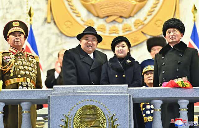 North Korean leader Kim Jong-un and his daughter Kim Ju-ae on a balcony surrounded by senior officials
