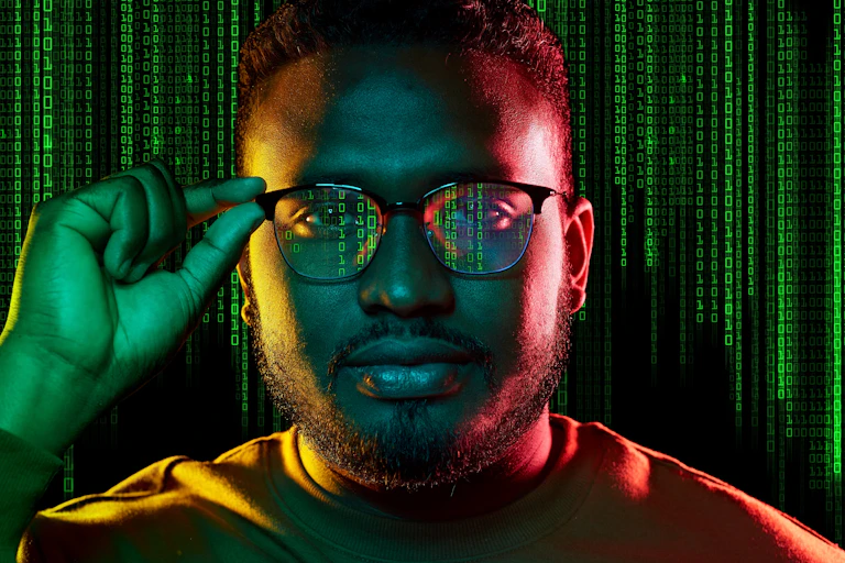 Man with lots of zeros and ones reflected in his glasses