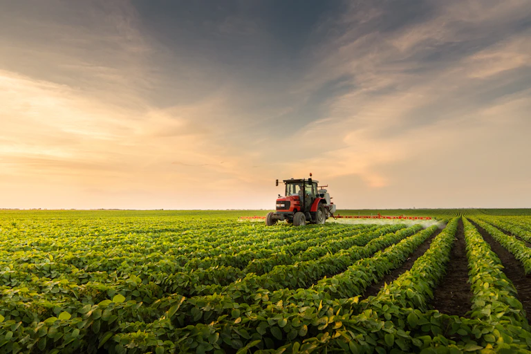 Tractor spraying pesticides in a field
