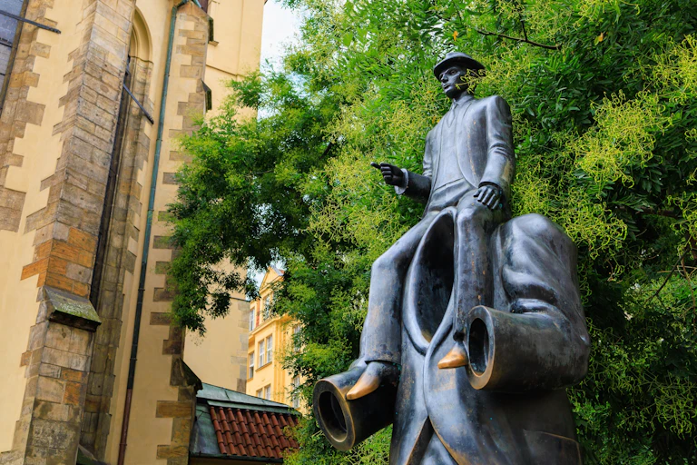 a statue of a man sitting on the shoulders of a larger, headless man