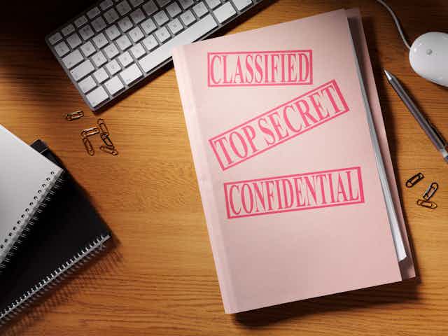 A manila folder with the words 'classified, top secret and confidential' stamped on it in red.