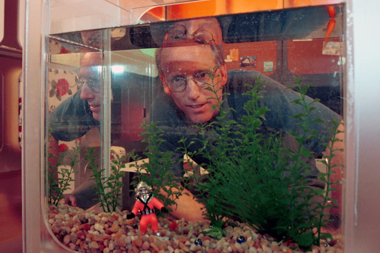 Man peering through an aquarium.