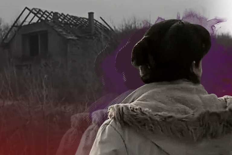 Woman with back to camera facing a derelict house