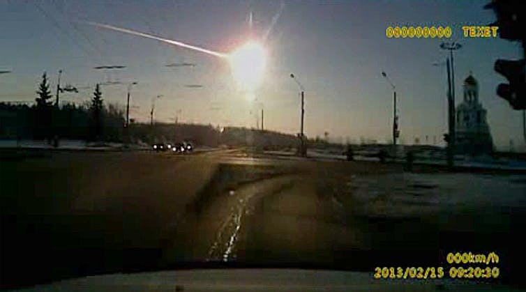 A dashboard camera photo shows a bright burst and trail of light across the sky.