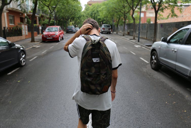 Boy walks down a road