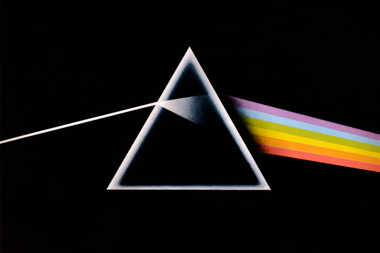 A black square album cover with a triangle prism showing refraction of a rainbow of light.