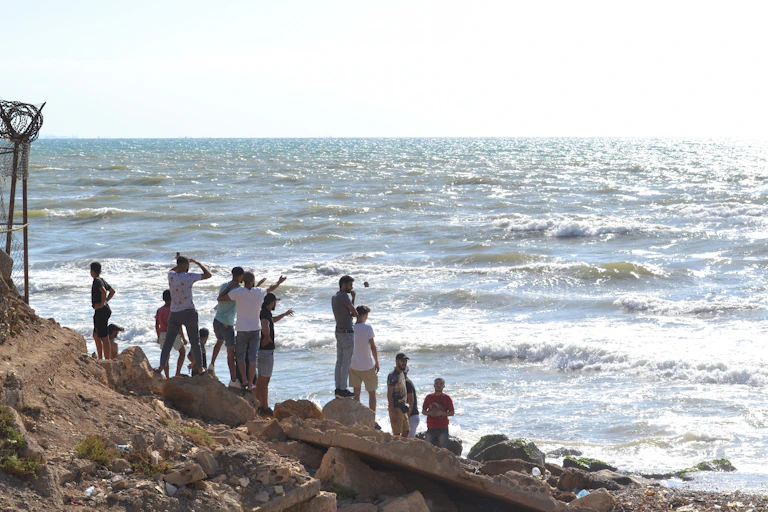 Personnes sur une plage en train de regarder la mer