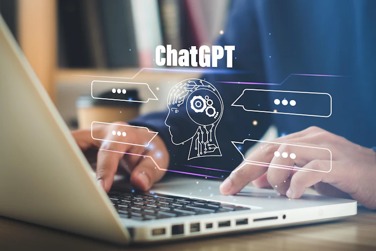 Manos escribiendo en un portátil con un símbolo de ChatGPT superpuesto.
