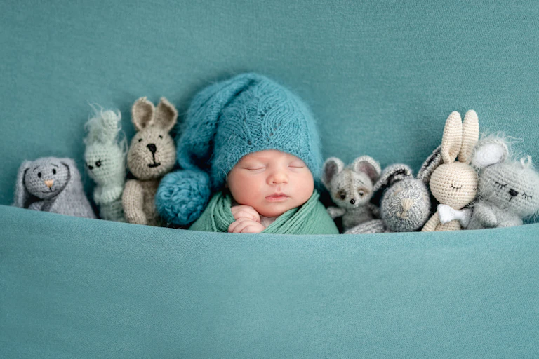 baby in beanie sleeping next to toys