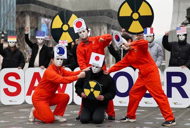 Environmental activists give a performance calling for Japan to call off its decision to release radioactive water from the crippled Fukushima nuclear power station into the ocean during a rally in Seoul, South Korea, 28 February 2023.