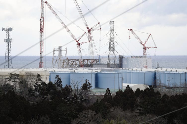 Reactor houses one and two at Tokyo Electric Power Company's Fukushima Daiichi Nuclear Power Plant, which is being decommissioned. Storage tanks of decontaminated water are also visible.