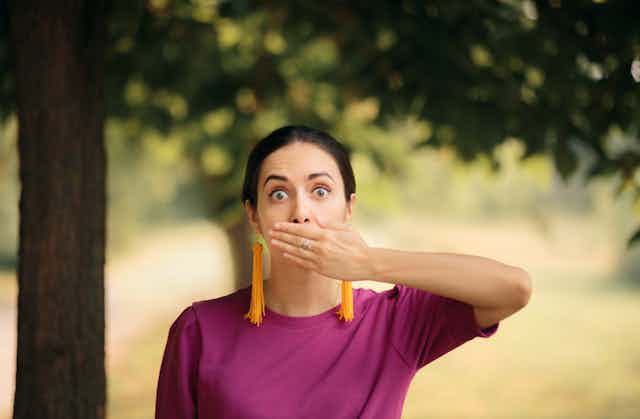 Woman with the hiccups holds her mouth