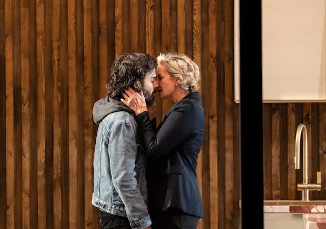 Assaad Bouab and Janet McTeer stand nose to nose as if about to kiss. Her hands are on his face.
