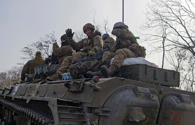 Ukrainian soldiers ride an armoured personnel carrier near the townof Bakhmut, eastern Ukraine, February 2023.