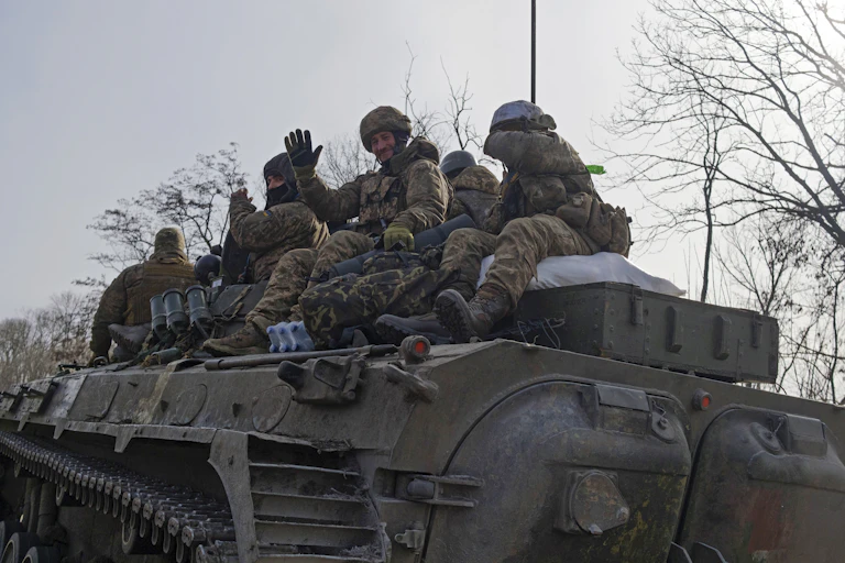 Ukrainian soldiers ride an armoured personnel carrier near the townof Bakhmut, eastern Ukraine, February 2023.