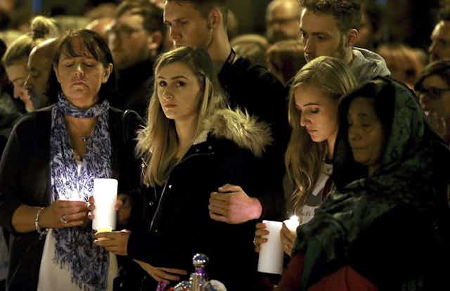 People attend a vigil for the attack victims in Manchester. 