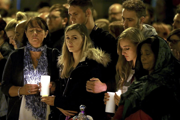 People attend a vigil for the attack victims in Manchester.