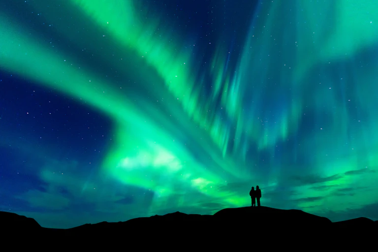 Aurora borealis with silhouette of hilltop