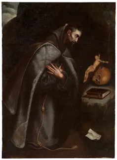Un hombre vestido de fraile se arrodilla y medita.