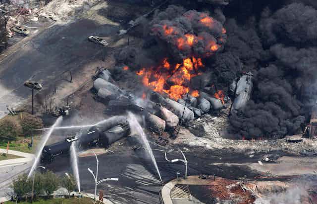 De la fumée se dégage de wagons contenant du pétrole brut après le déraillement d’un train