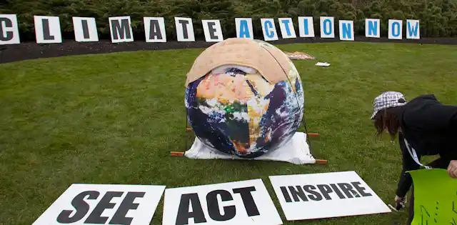A person seen bending over signs that say see, act, inspire