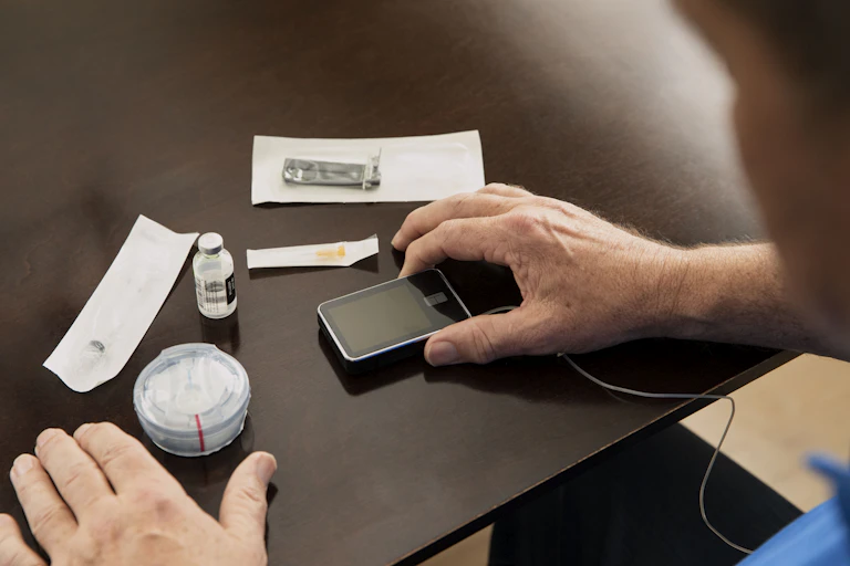 A man's hands and insulin supplies.