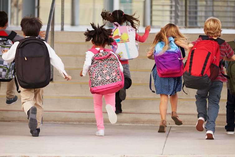 School kids from behind, with backpacks