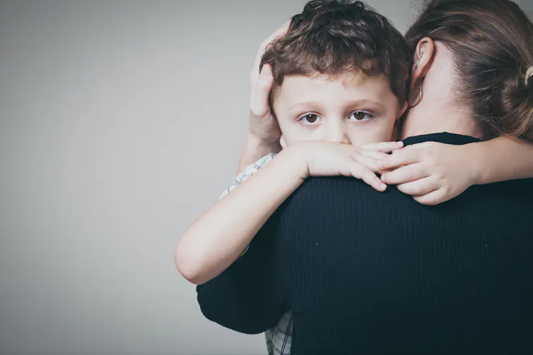 triste fils embrassant sa mère à la maison