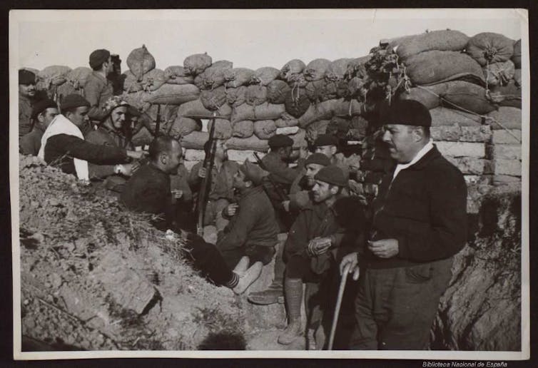 Soldados sentados en una trinchera.