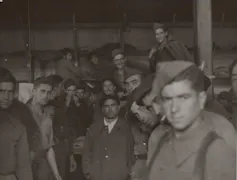 Prisioneros miran a cámara.
