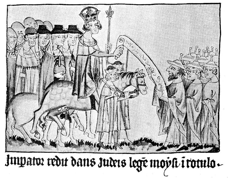 A black and white illustration of a group of people with pointed hats receiving a document from a king on horseback.