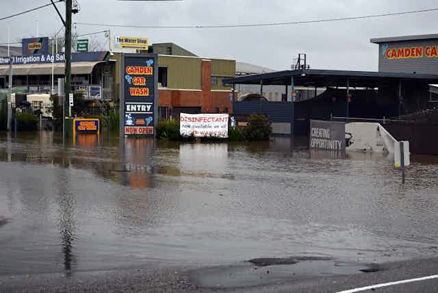 Shops and car wash along a flooded street