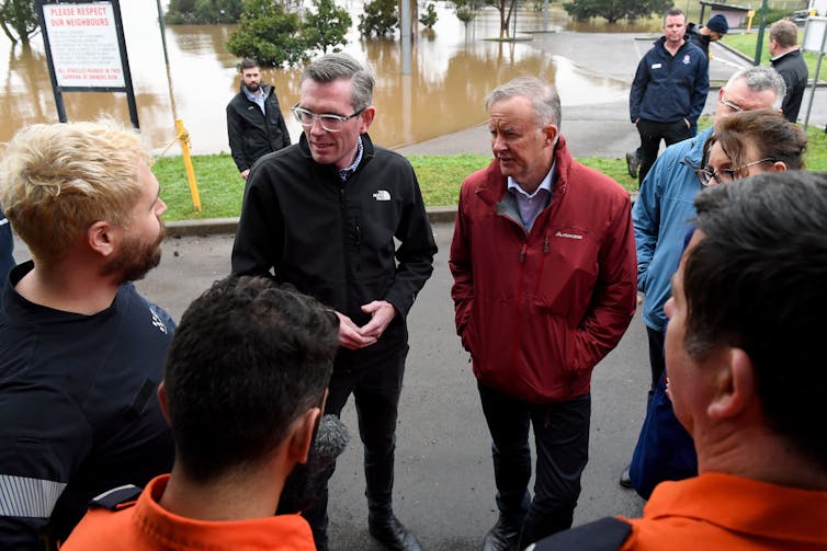 Two politicians – Dominic Perrotet and Anthony Albanese – talk with residents affected by floods