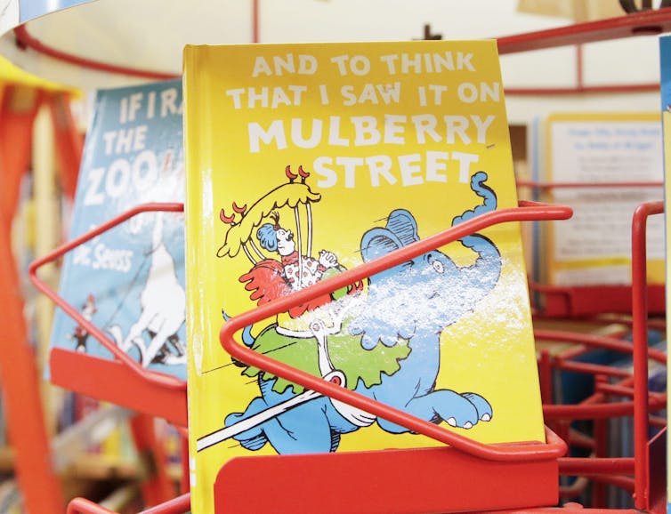 A copy of And to Think That I Saw It On Mulberry Street with a yellow cover and a blue elephant on the front