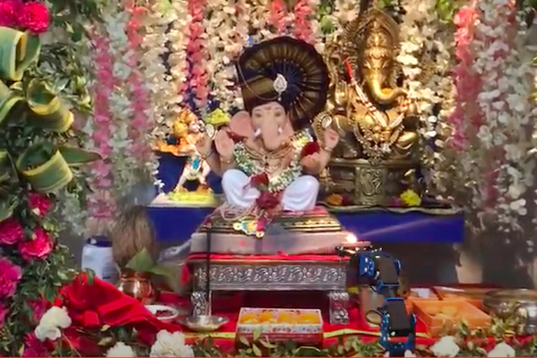 A statue of the Hindu god Ganesha with flowers around it.