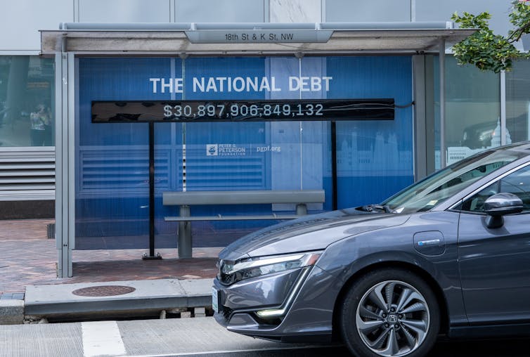 National debt counter sign in bus stop
