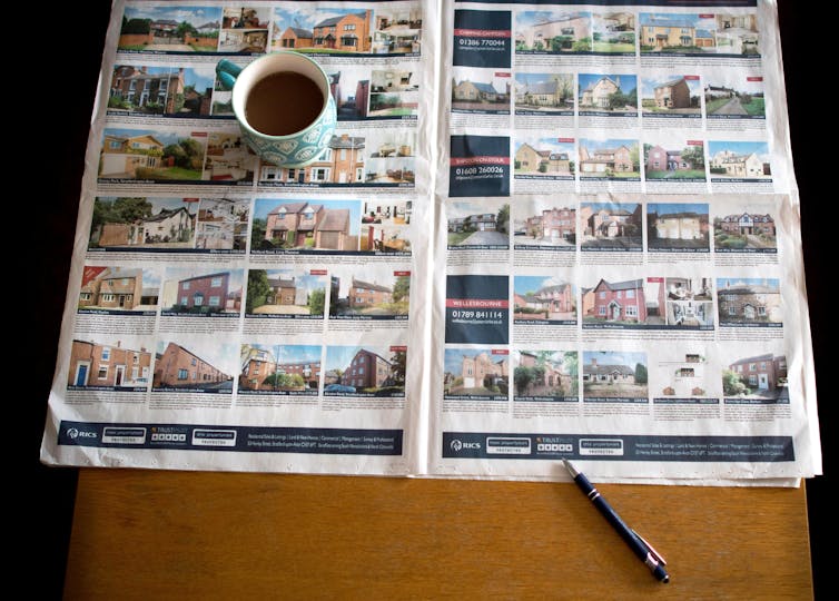 Estate agents' brochure with a coffee mug on top