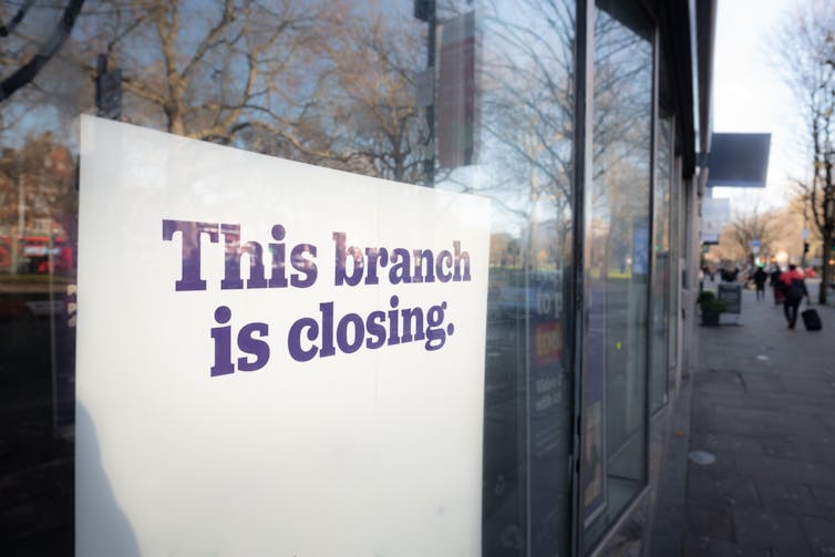 Sign in window of bank branch that is due to close
