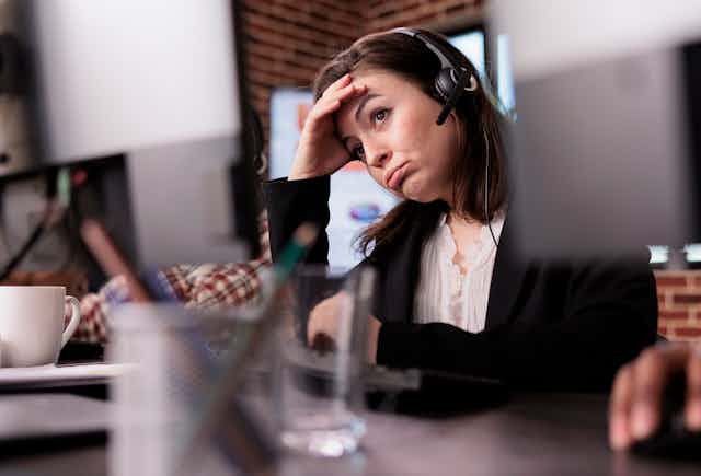 Young woman wearing a headset looking tired
