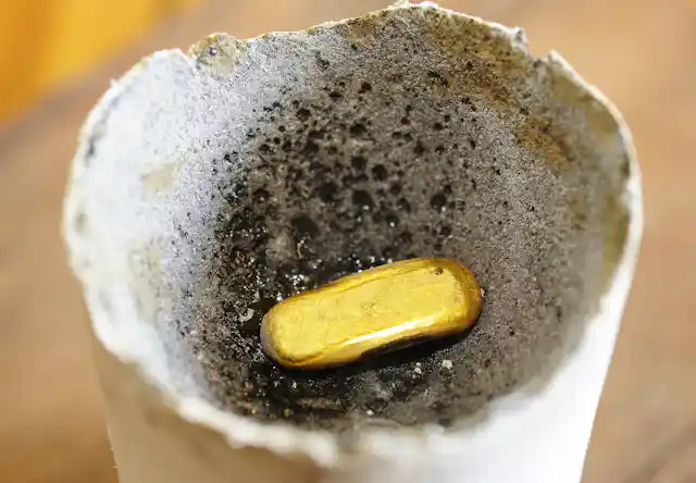 A small piece of gold in a ceramic crucible