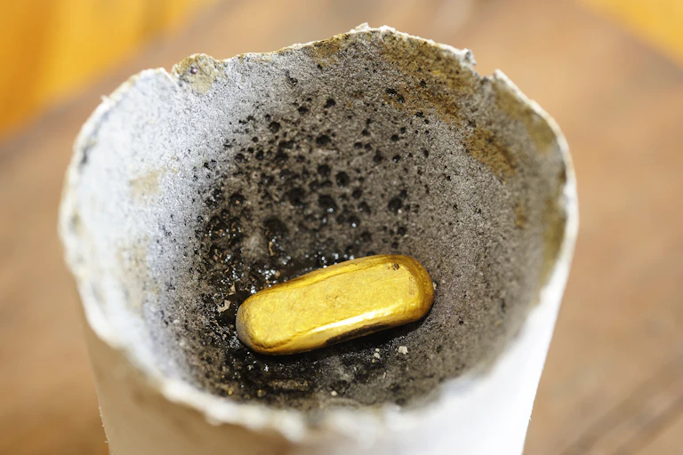 A small piece of gold in a ceramic crucible