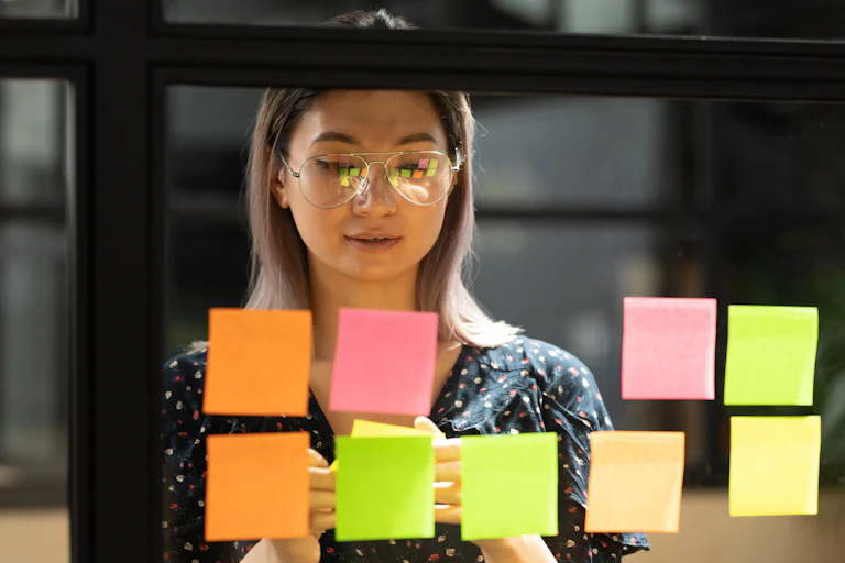 A woman puts sticky notes on a window