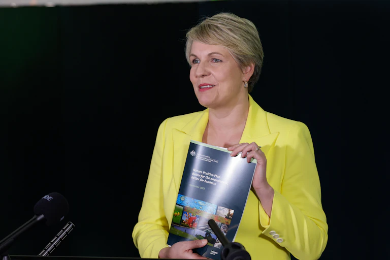 Women in yellow jacket holds up a glossy report