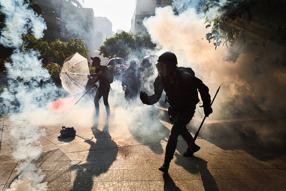 Des manifestants anti-gouvernementaux de Hong Kong encerclés par des gaz lacrymogènes lors d'un affrontement avec la police anti-émeute à Wong Tai Sin, le 1 octobre 2019